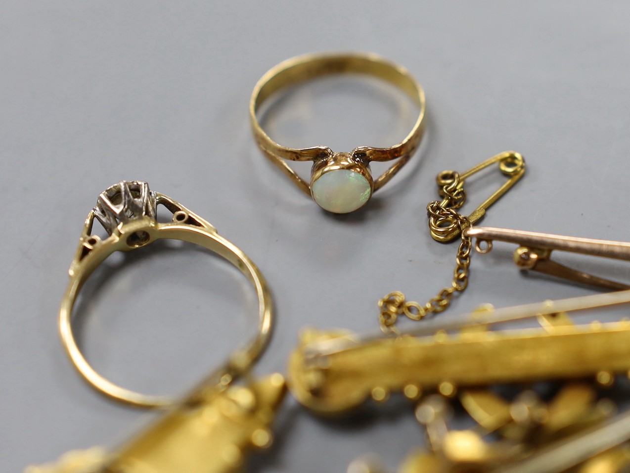 Two early 20th century 9ct and gem set bar brooches, gross weight 4.7 grams, a similar 15ct horseshoe bar brooch, gross 3.4 grams, two other yellow metal and gem set bar brooches, gross 10 grams, a 22ct gold and white op